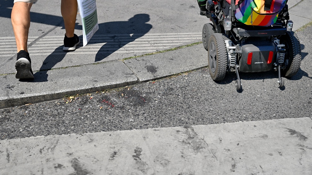Fußgänger und Rollstuhlfahrer auf der Straße, Zebrastreifen
