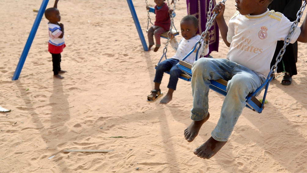Flüchtlingskinder aus dem Sudan auf Schaukeln