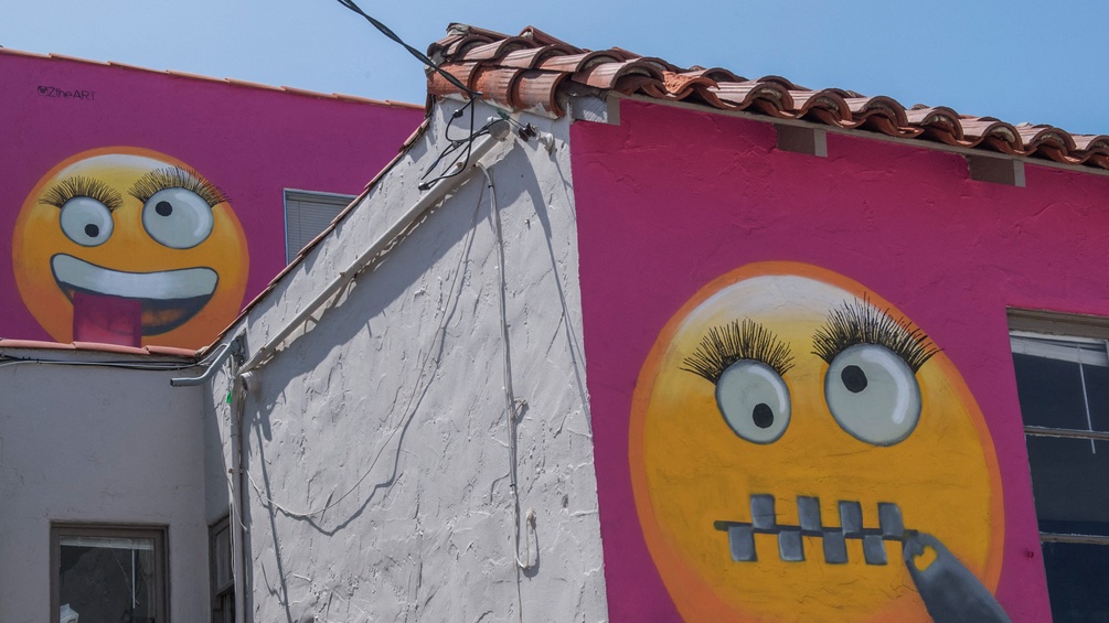 Zwei Emojis als Grafitti auf einer Hauswand.