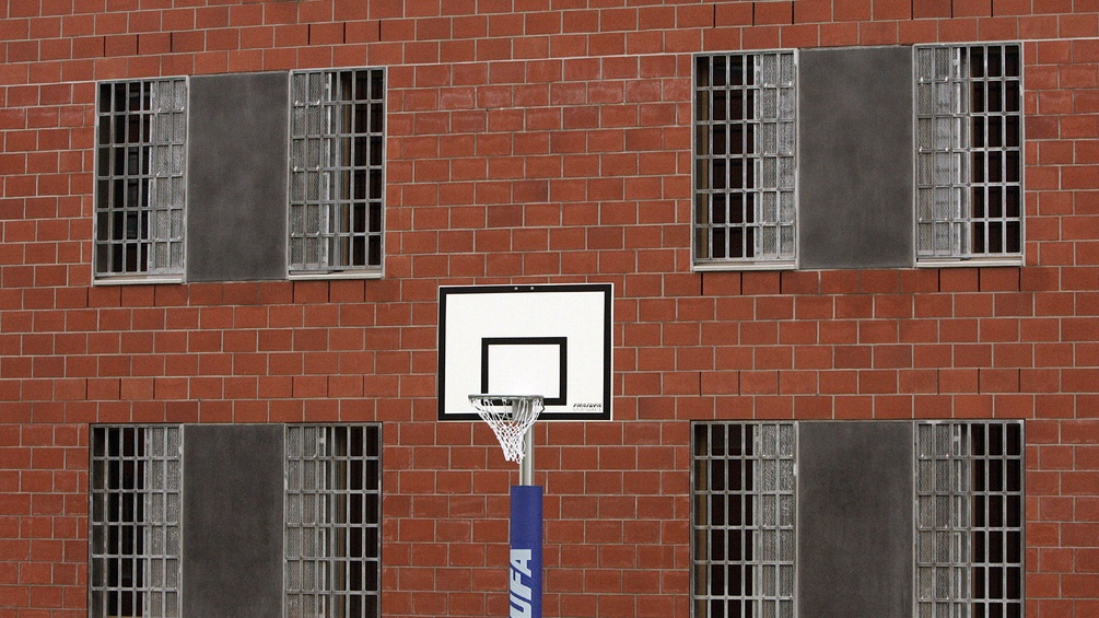  Ein Basketball-Korb steht vor der Fassade mit vergitterten Fenstern eines Zellentraktes im Außenbereich der Justizvollzugsanstalt Hünfeld.