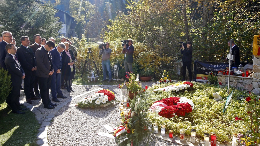 Kränze, Kerzen sowie Teilnehmer im Rahmen einer Gedenkveranstaltung zum 10. Todestag von Jörg Haider