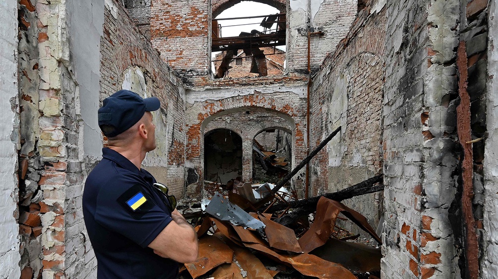 Ukrainischer Mann in Uniform in einem zerstörten Haus