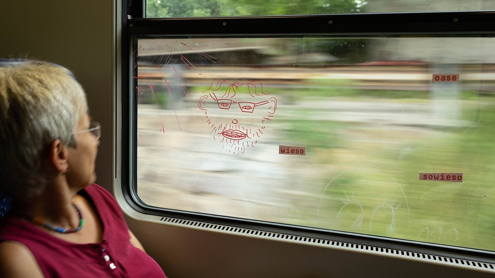 Festival der Regionen 2023: Frau im Zug blickt aus dem Fenster