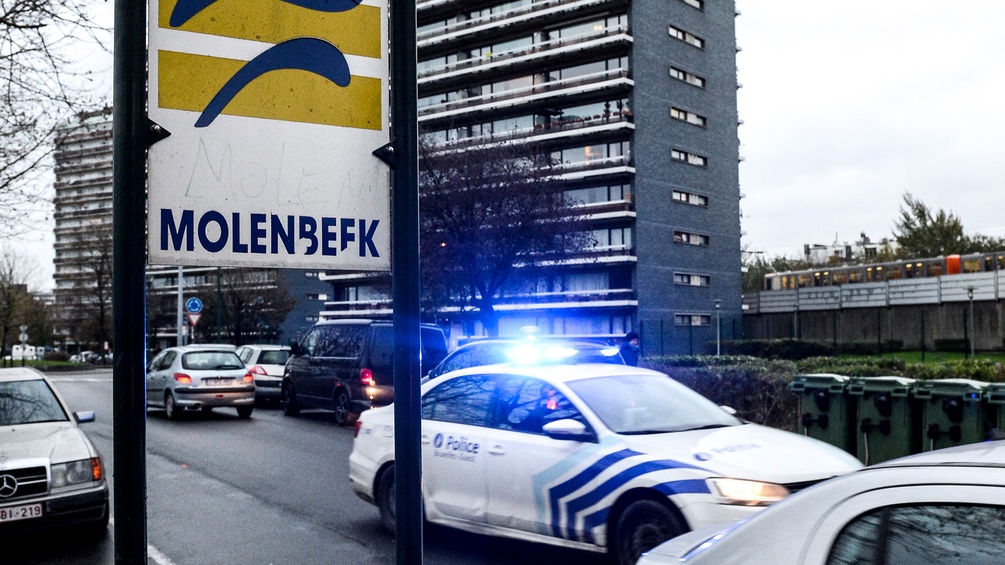  Ein Molenbeek Schild vor einem Gemeindebau und einem Polizeiwagen