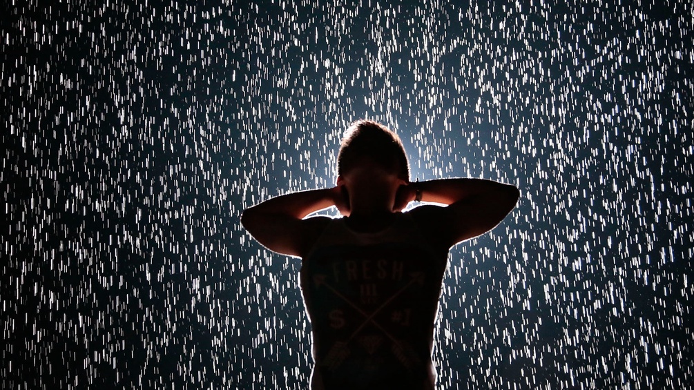 Mann steht im Regen