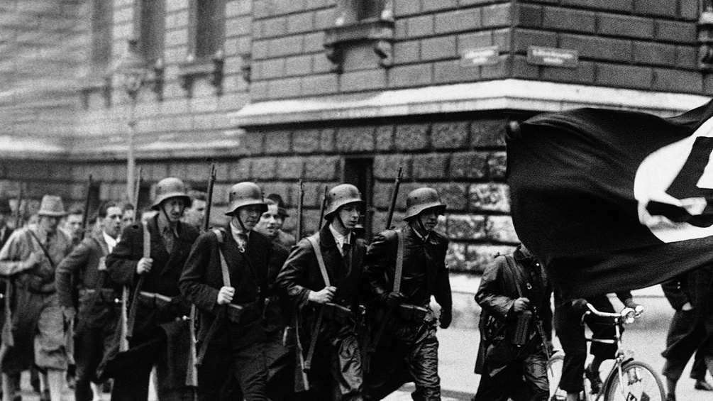 Bewaffnete Nationalsozialisten mit Fahne, 1938