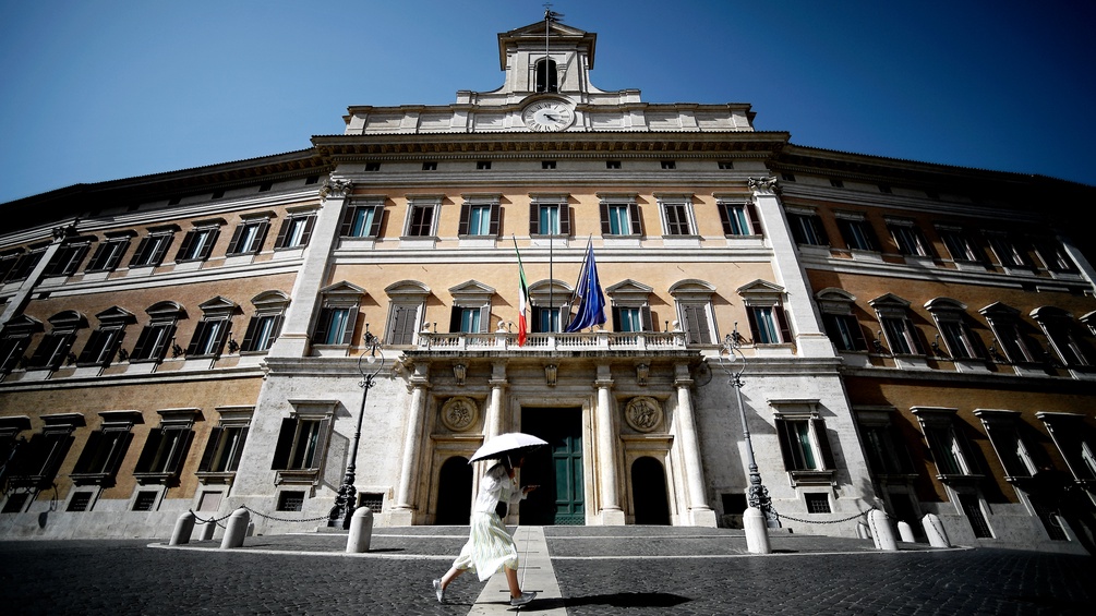 Eine Frau spaziert an dem italienischen Parlament vorbei