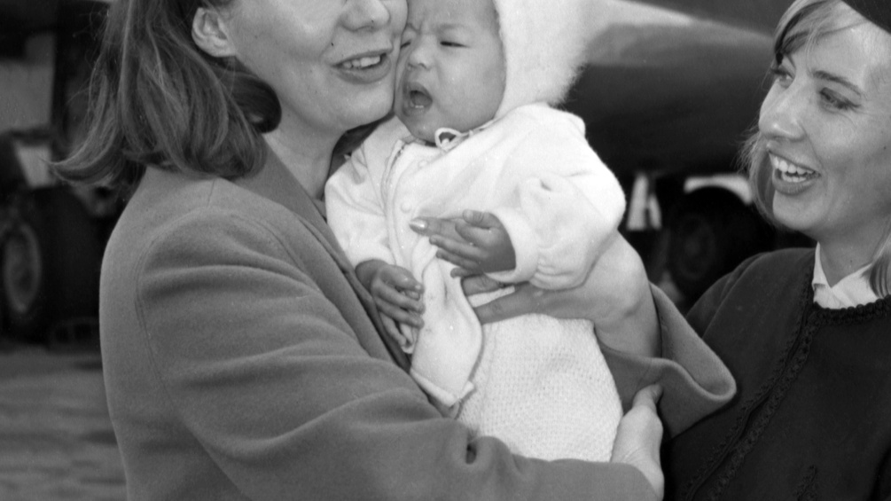 Eine Frau übernimmt am Flughafen ein Baby