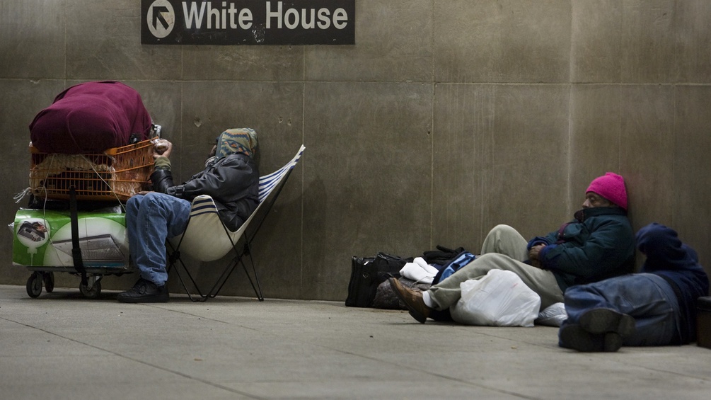 Obdachlose in einer Ubahnstation unter dem Wegweise zum Weissen Haus