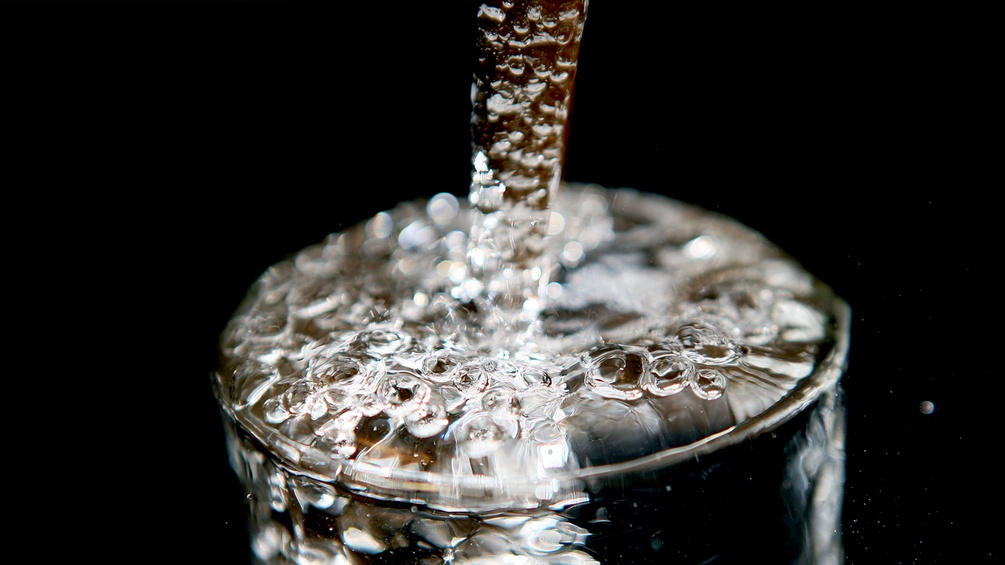 Ein Glas wird mit Wasser aufgefüllt