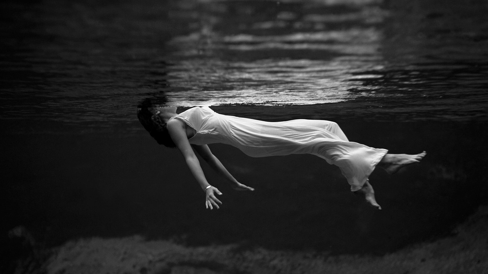 Eine Frau schwebt unter der Wasseroberfläche.