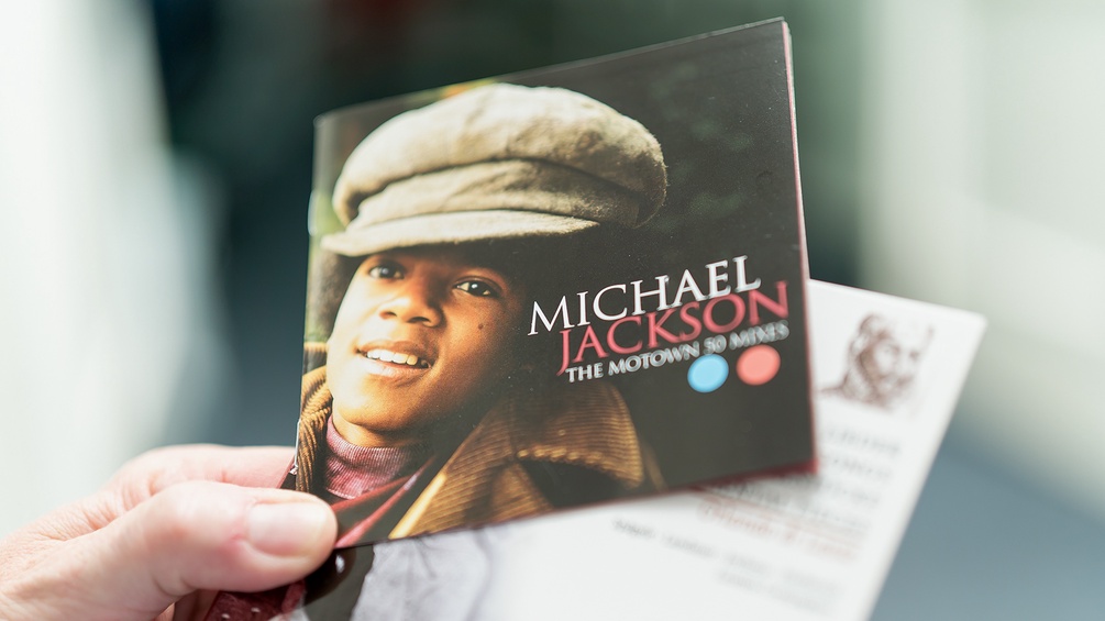 Albert Hosp hält zwei CDs in Händen, eine zeigt Michael Jackson