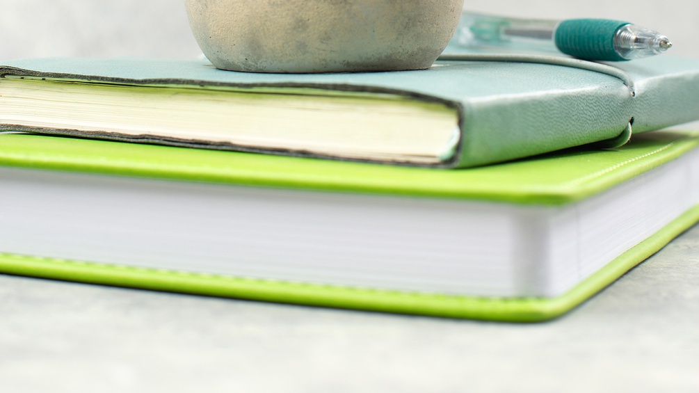 Buchstapel und Kugelschreiber