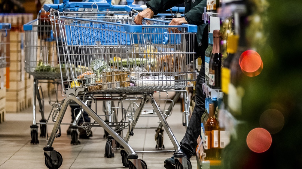 Menschen kaufen zu Weihnachten im Supermarkt ein.