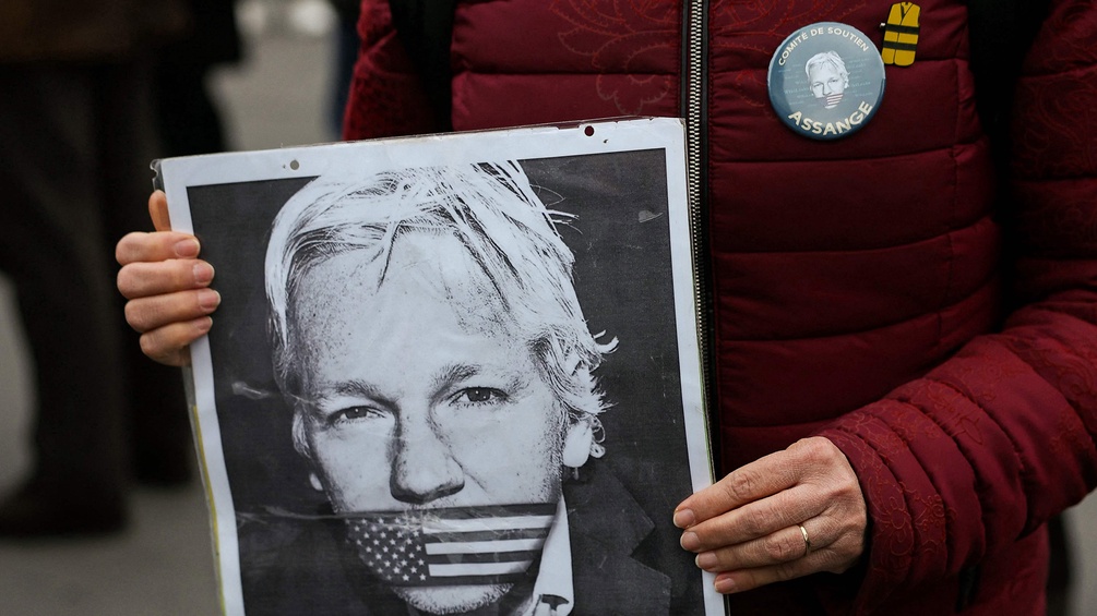 Julian-Assange-Plakat in Händen einer Frau
