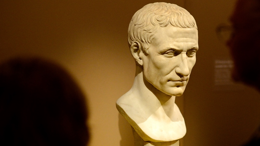 Ceasars Büste wird von Besuchern in einem Museum betrachtet.