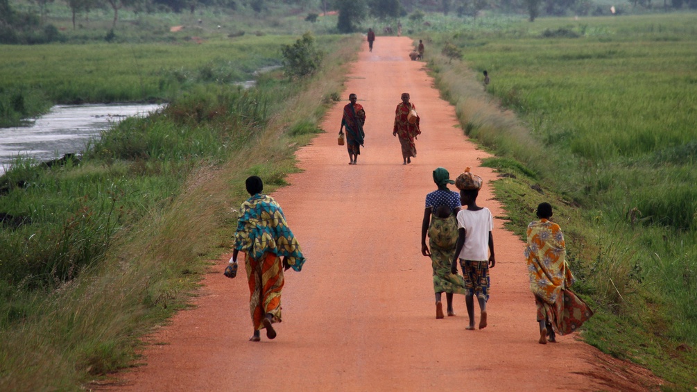 Menschen gehen auf einer Landstraße in Burundi