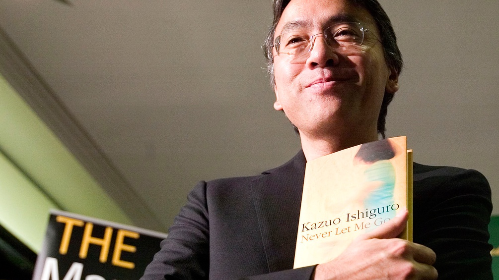 Kazuo Ishiguro mit einem Buch in der Hand