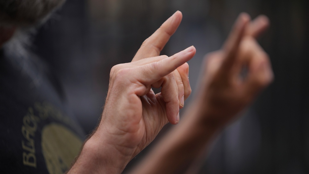 Ein Mann im Black Sabbath Tshirt hält die Hände in die Höhe