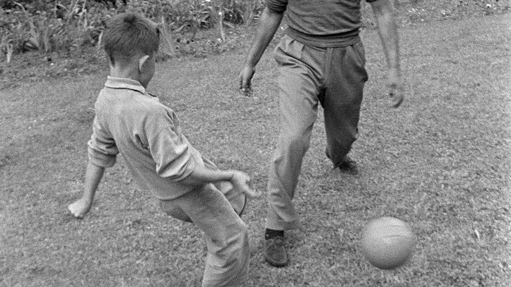 Ein Vater spielt mit seinem Sohn Fußball.