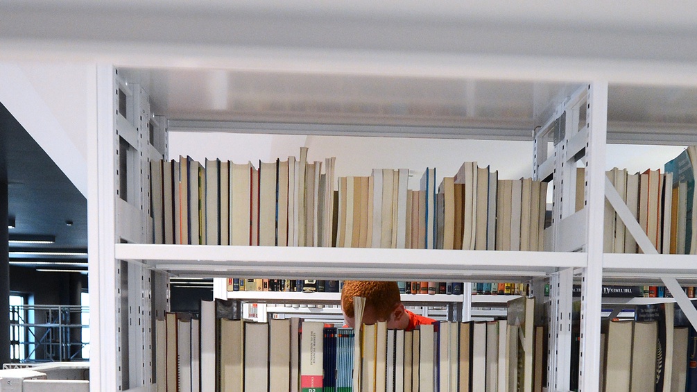 Ein weißes Bücherregal mit vielen Büchern.