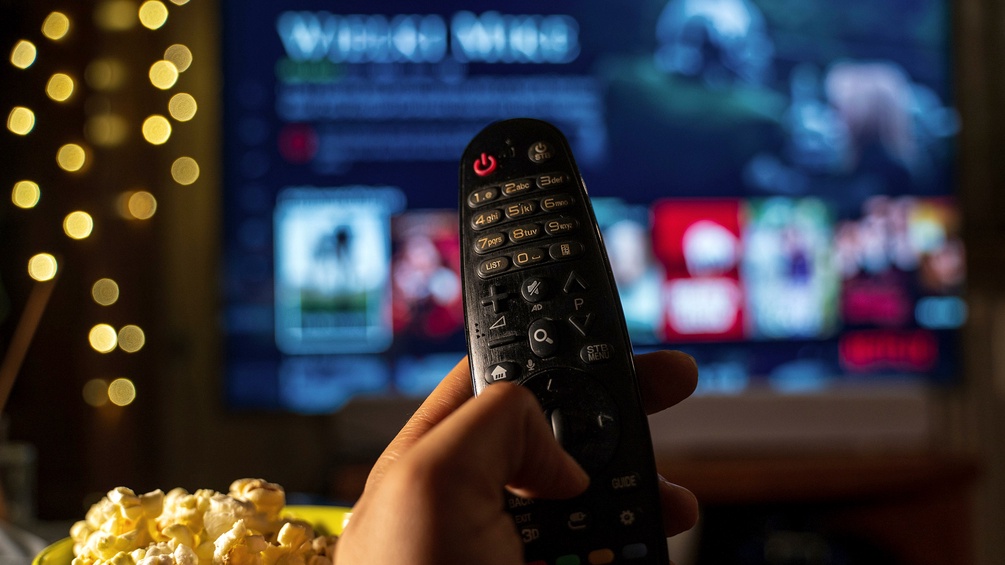 Popcorn, Fernbedienung und Netflix im Hintergrund
