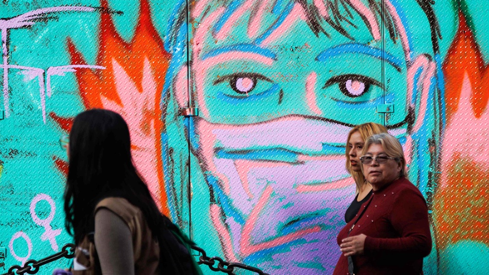 Frauen in Mexiko vor einem Grafitti