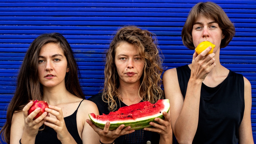 Drei junge Frauen essen Füchte