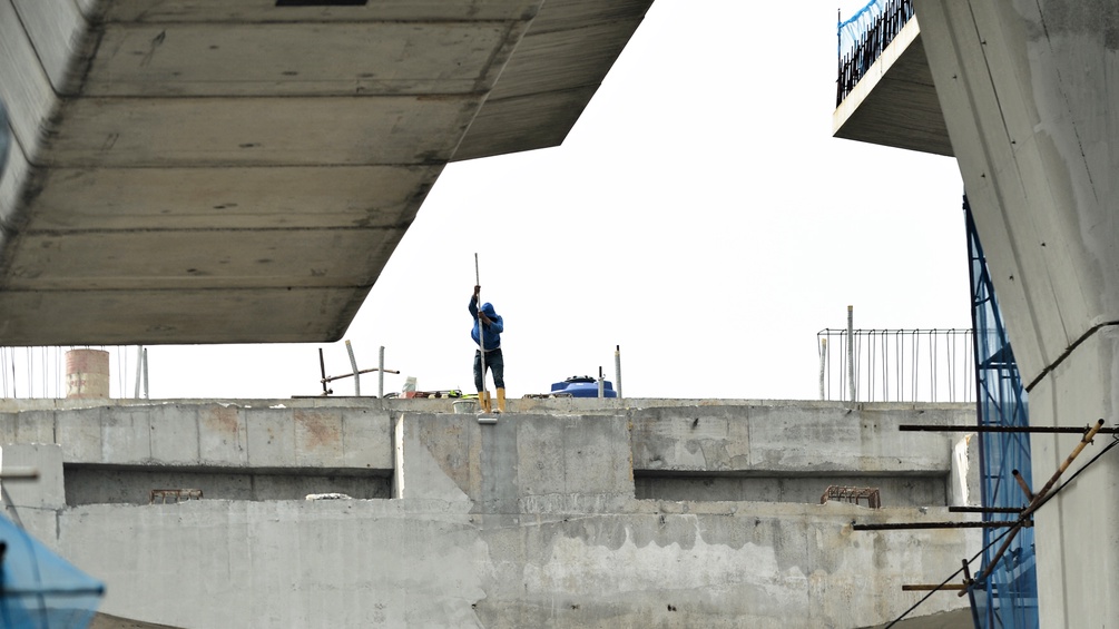 Ein Indonesischer Arbeiter säubert eine Beton Oberfläche