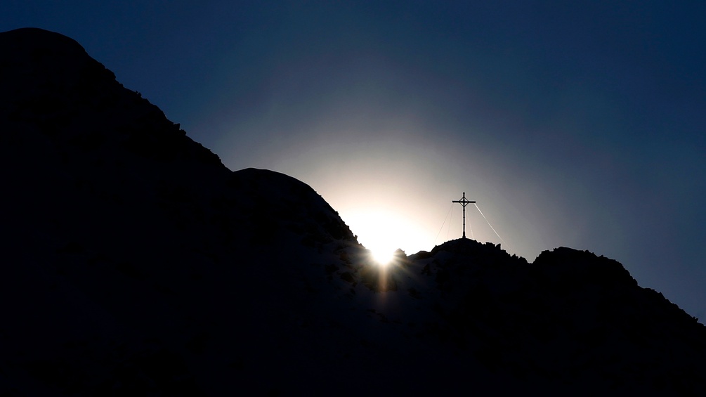 Die Sonne leuchtet ein Kreuz an nähe Montafon, Austria