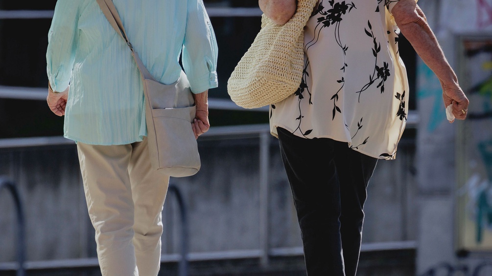 Die Rücken zweier Damen mit Handtaschen 