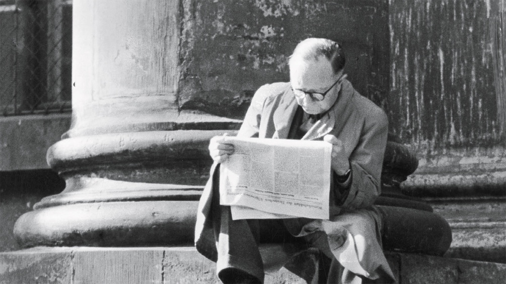 Mann sitzt auf Stufen und liest Zeitung, Ausschnitt Buchumschlag