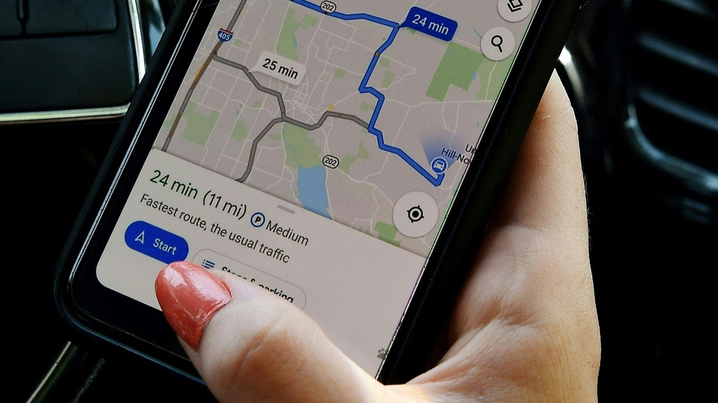 Eine Frau bedient Google Maps auf ihrem Smart Phone.