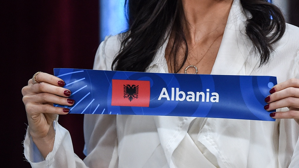 Eine Frau hält eine Schleife mit der Aufschrift "Albanien"