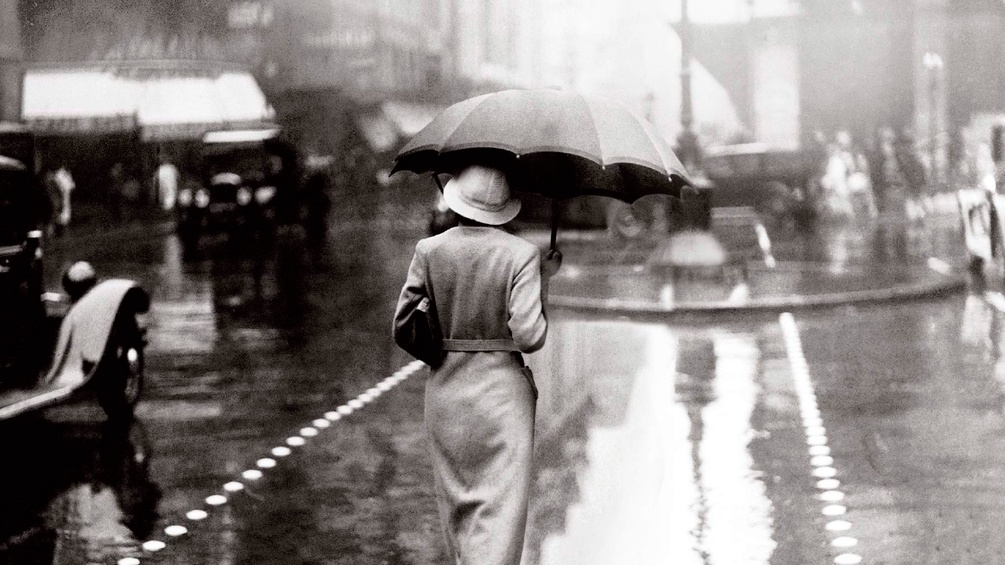 Ausschnitt des Buchcovers, Frau geht mit Regenschirm auf nasser Straße
