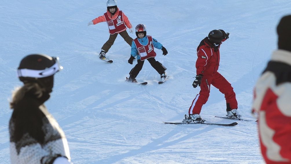 Skilehrerin und Schüler auf der Piste