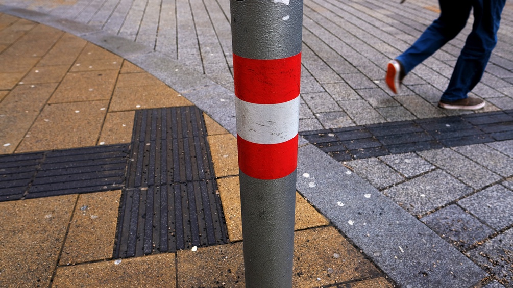 Kreuzung mit rot-weiß-rot markiertem Verkehrszeichen