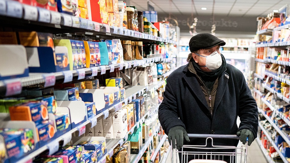 Mann mit Mundschutz im Supermarkt