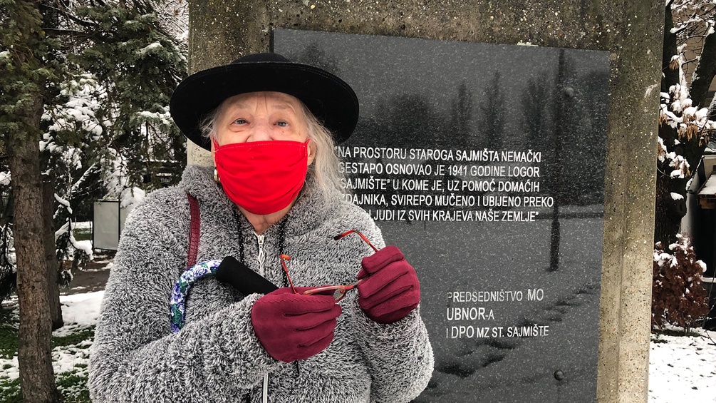 Ester Bajer vor einer Gedenktafel aus sozialistischer Zeit