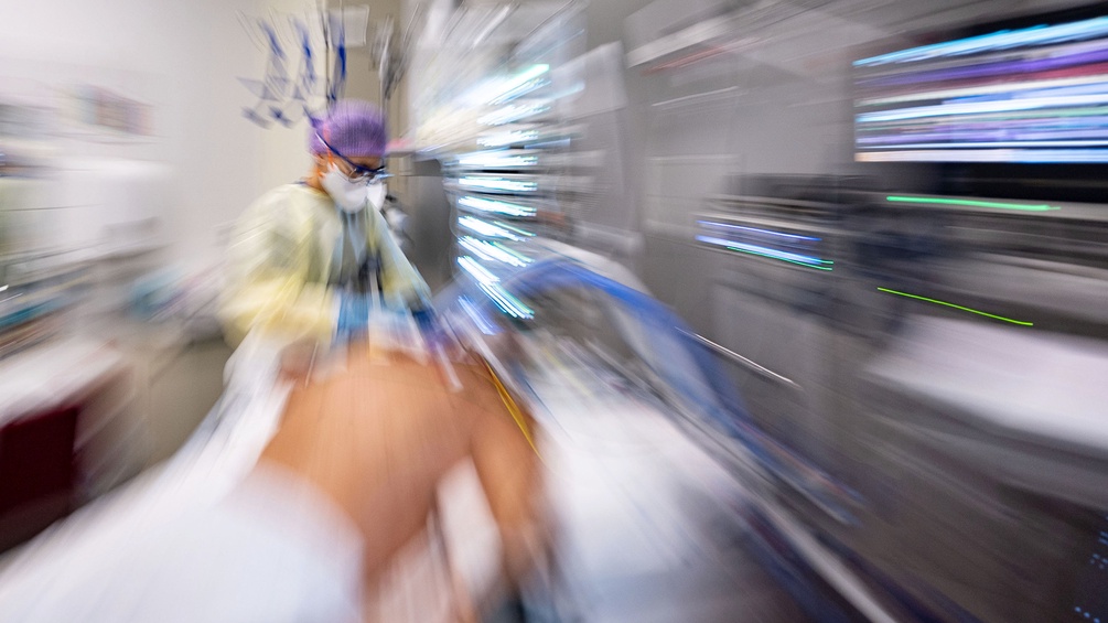 Covid-19-Patient im künstlichen Koma auf einer Intensivstation, Krankenschwester, Bewegungsunschärfe