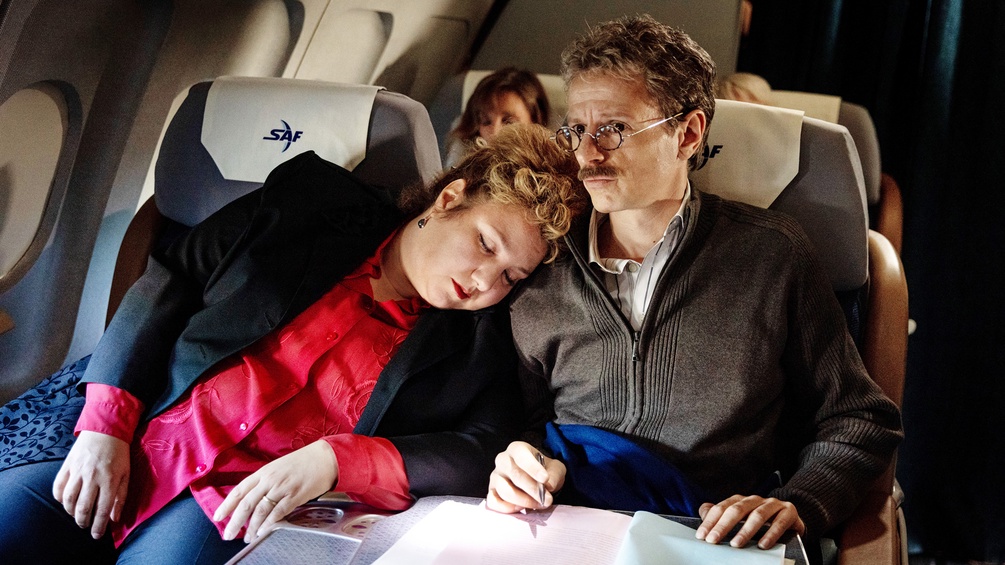 FILMLADEN FILMVERLEIH/LUNA ZSCHARNT Im Flugzeug: Frau schäft an der Schulter eines Mannes