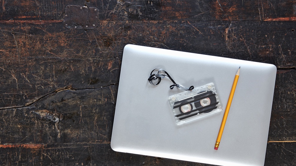 Macbook mit Bleistift und Musikkassette