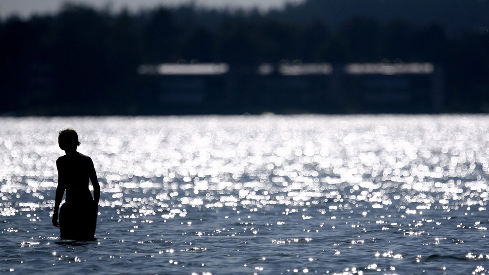 Eine Person im Wasser am Strand in Finnland