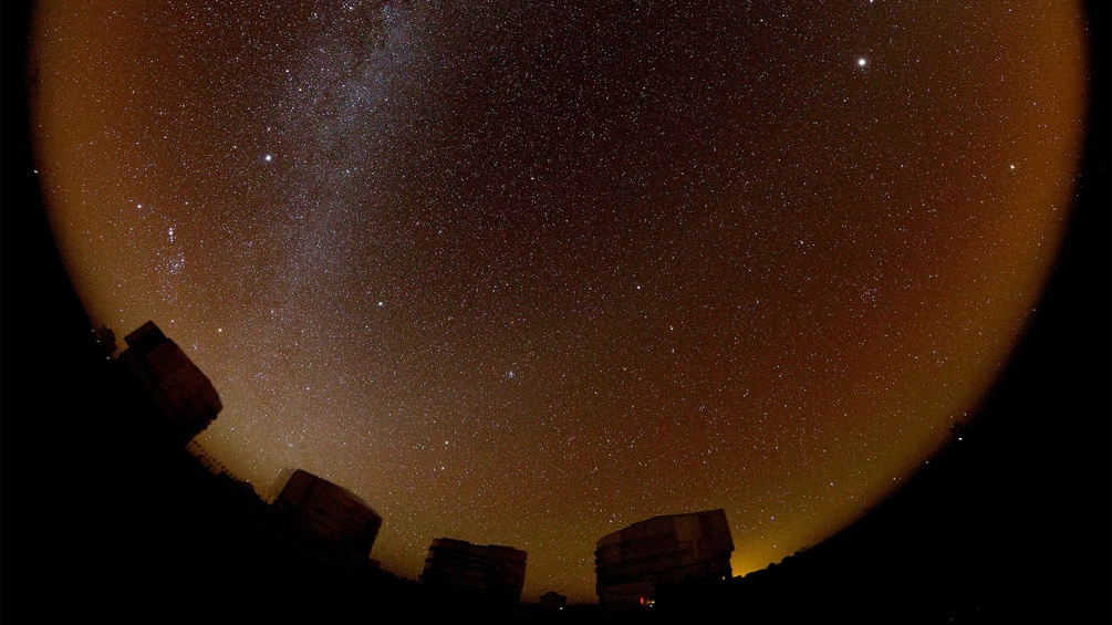 Der Südhimmel mit dem Band der Milchstrasse, unten die Teleskopkuppeln der Ezuropäischen Südsternwarte am Paranal (Ausschnitt)