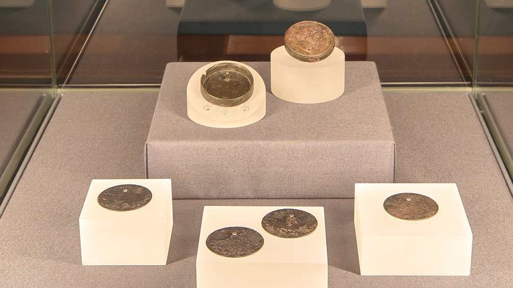 Ausstellungsansicht: Römische Taschensonnenuhr: Dose, Deckel, vier Einlagescheiben Bronze