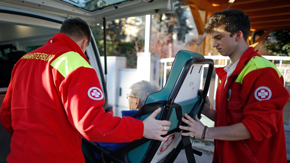 Samariter helfen einer alten Frau.