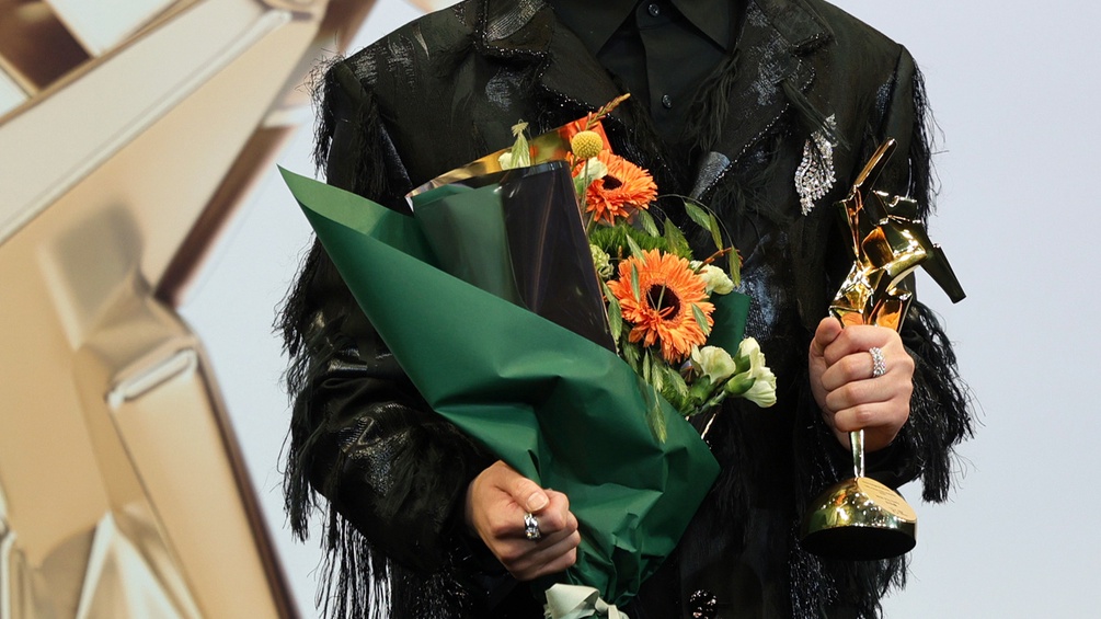 Musiker hält einen Preis des 18. Asian-Film-Awards