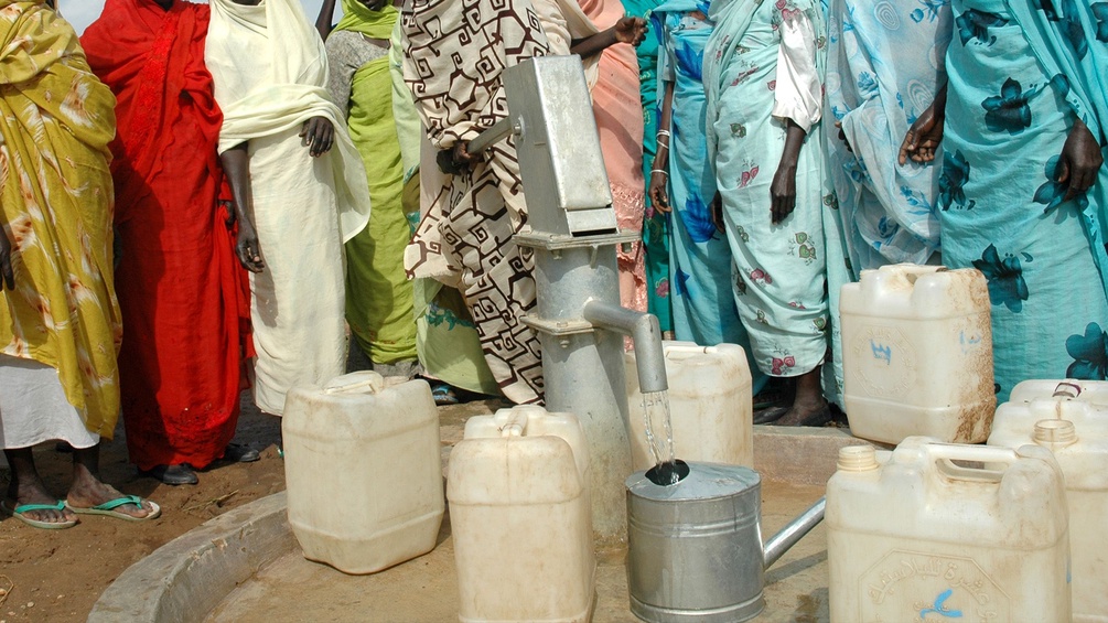 Frauen in Entwicklungsländern beim Wasser holen.