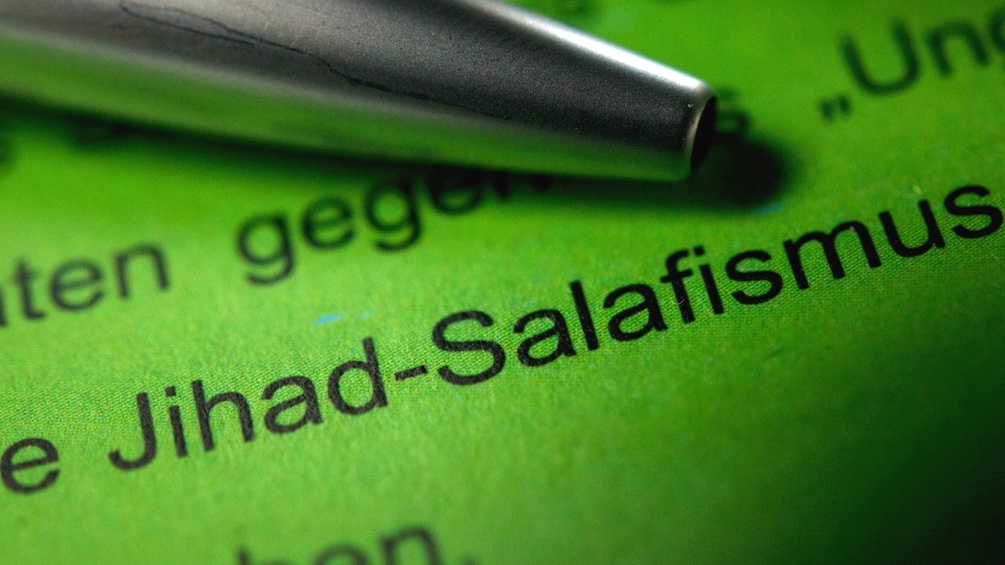 Schwarze Schrift auf grünem Hintergrund, zu lesen sind die Wörter "Jihad-Salafismus"