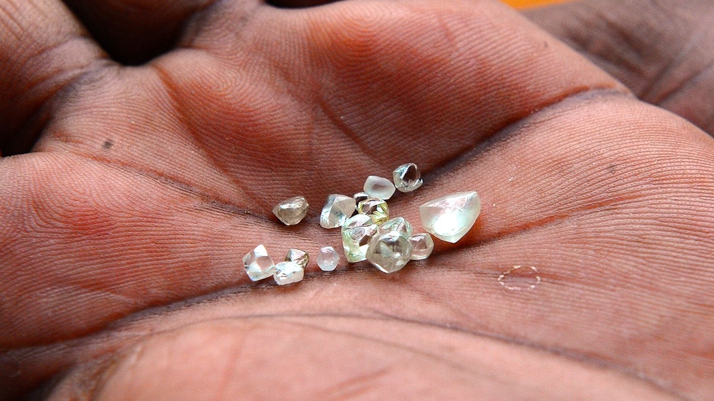 Rohdiamanten liegen auf einer Hand